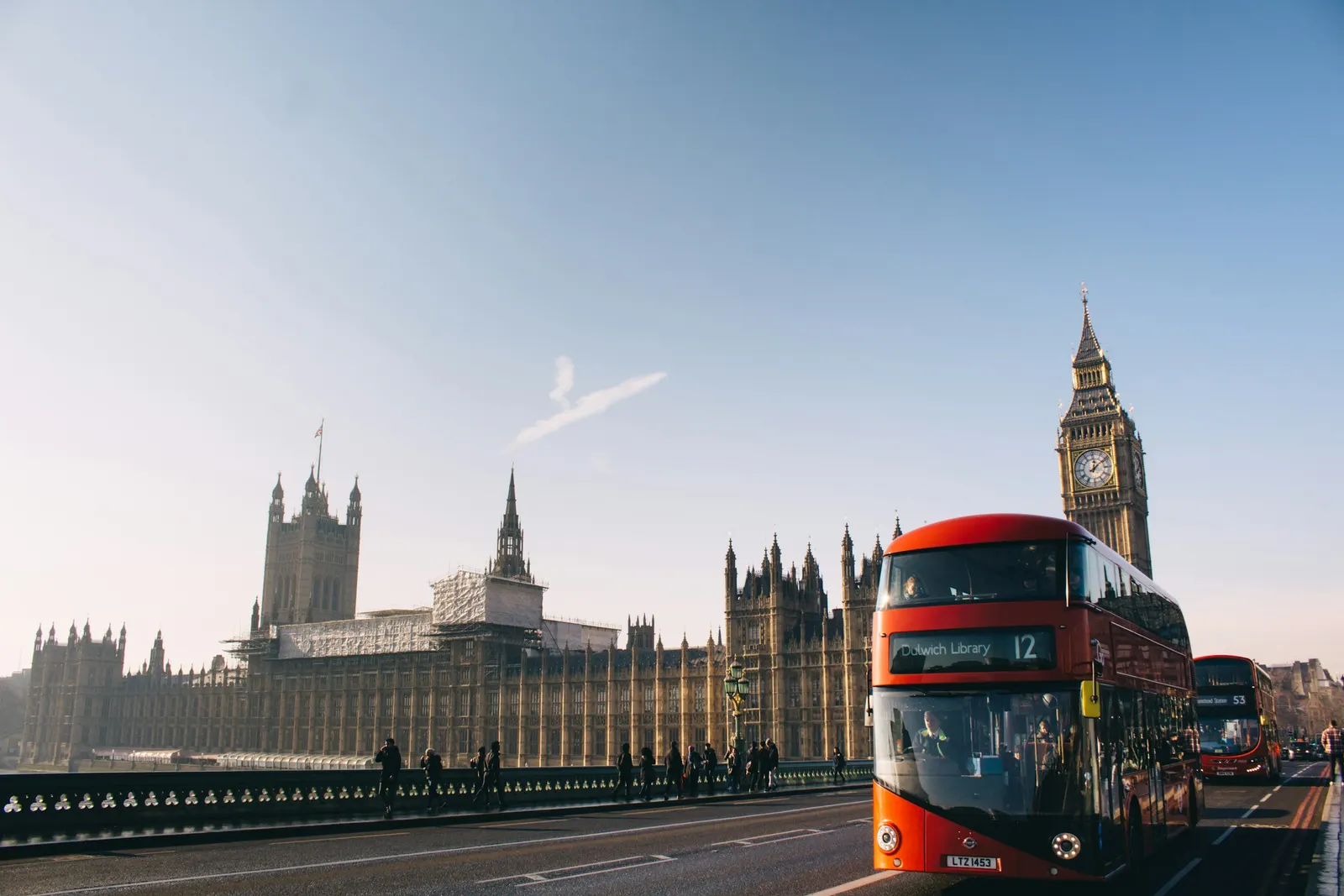 A red double-decker bus passing the Palace of Westminster, London